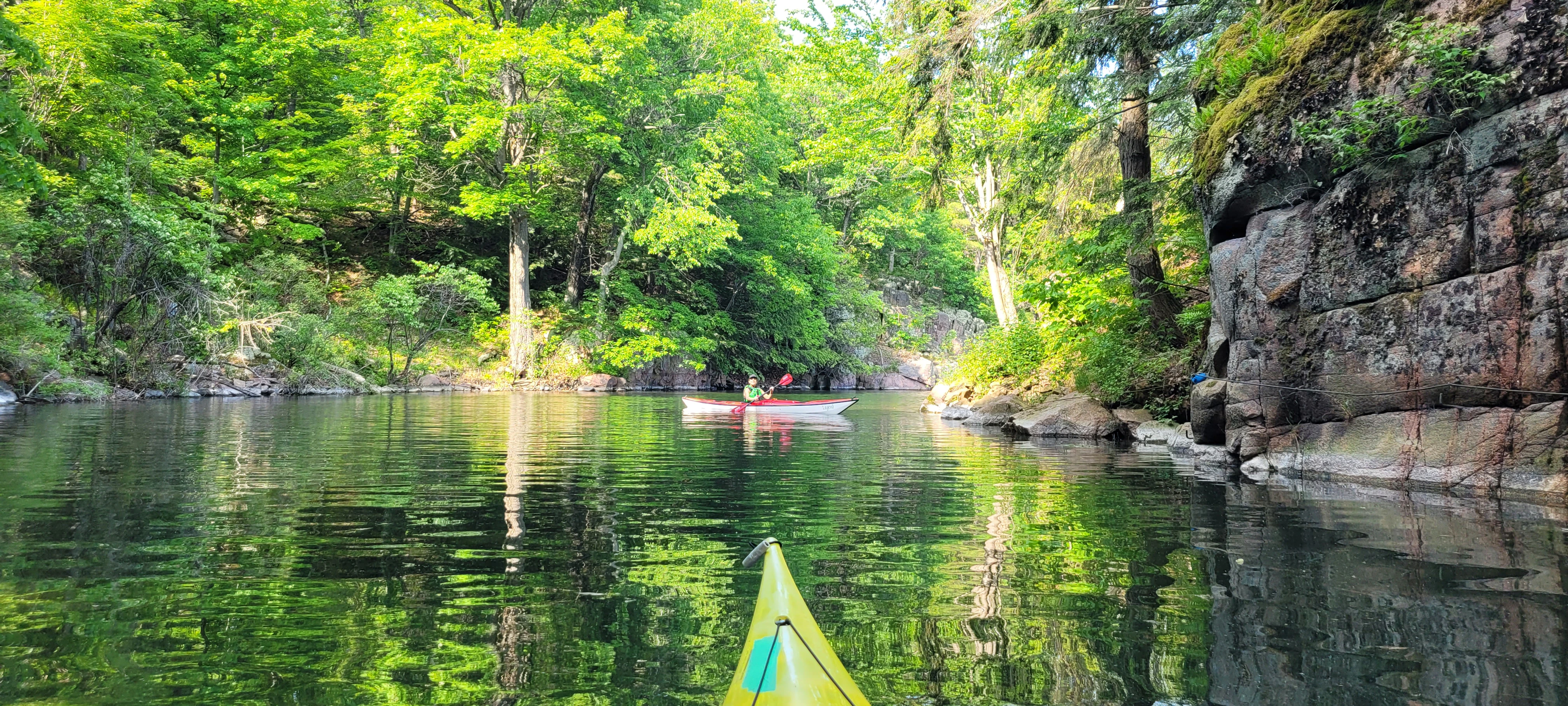 Colorful trees reflecting off of the water at the mouth of Half Moon Bay on a kayak trip to the Thousand Islands in Ontario Canada